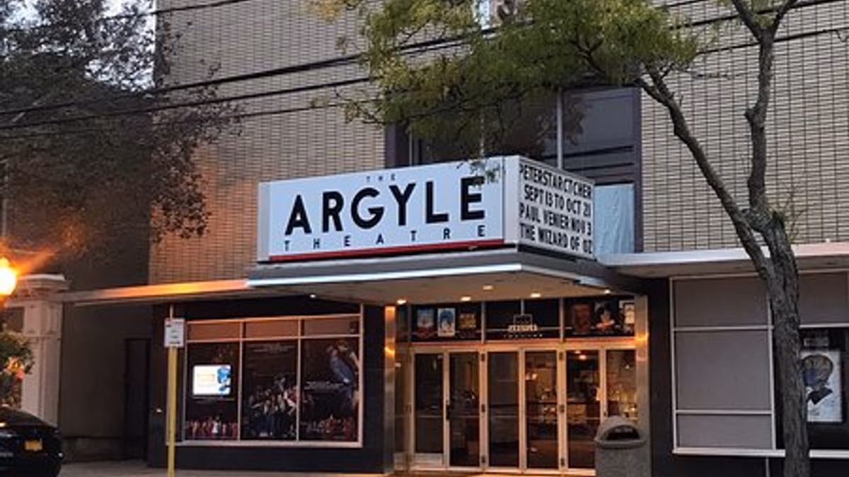 Cabaret stage at the Argyle Theater Babylon with a singer at a microphone and table seating